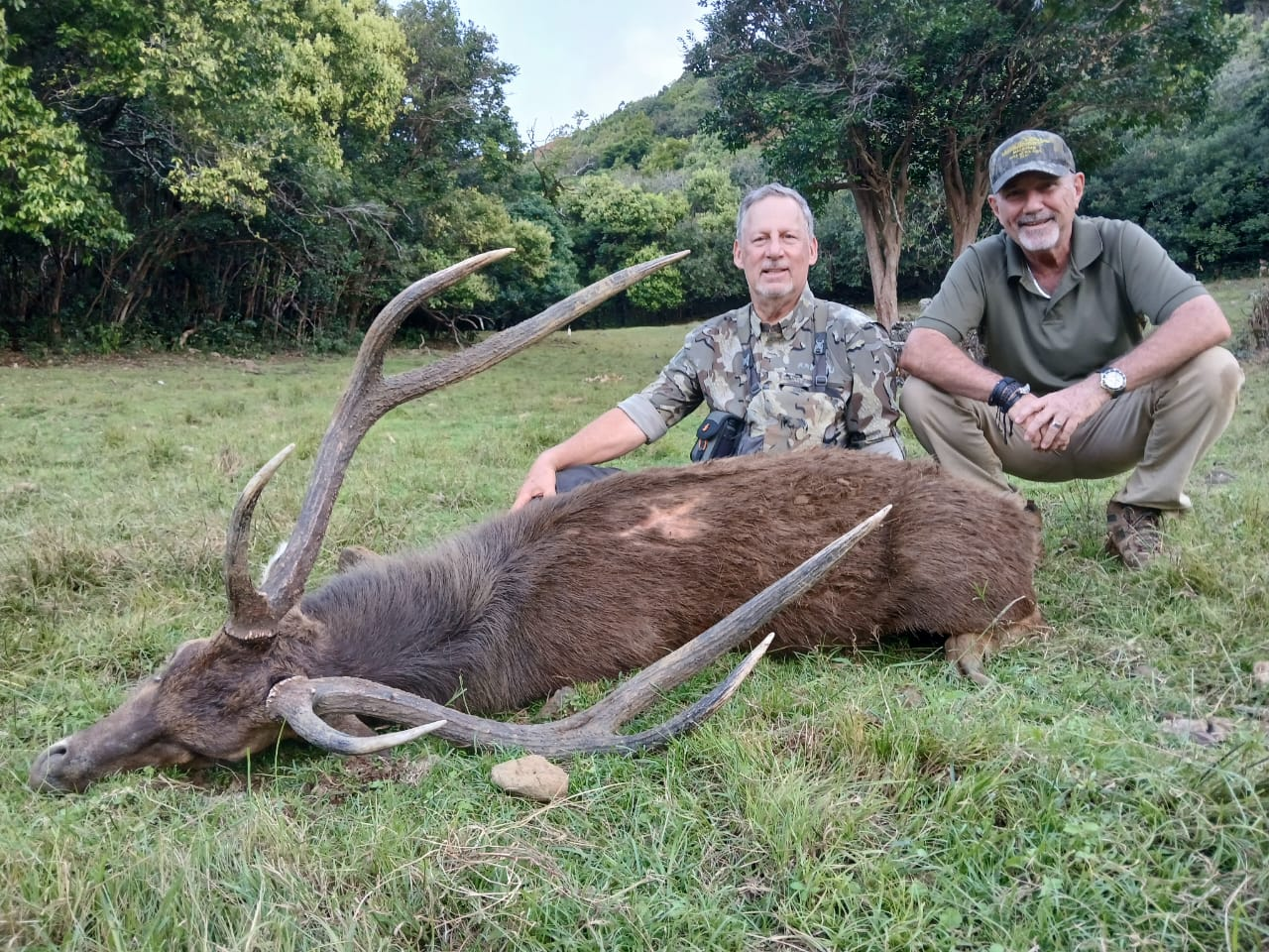 Hunters with Rusa deer trophy in Mauritius landscape